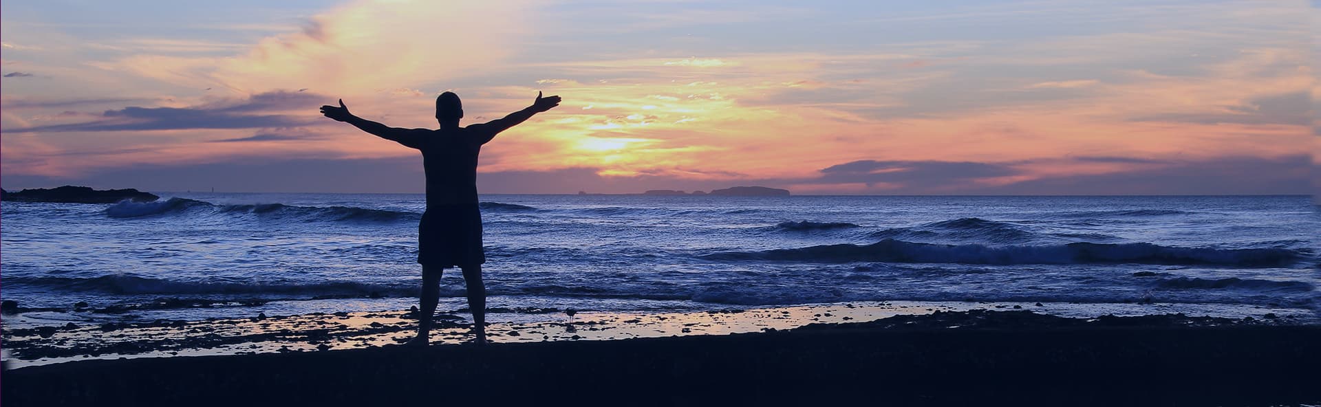 person with open arms at ocean